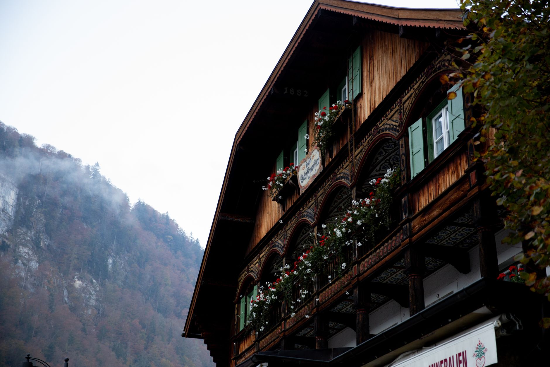 Holzhaus mit Blumenbalkon in den Bergen